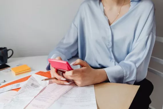 Interest rates Woman sitting on desk making calculation